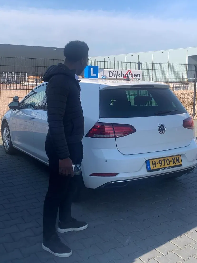 Djakaman Verbaan bij de lesauto van Verkeersschool Dijkhuizen